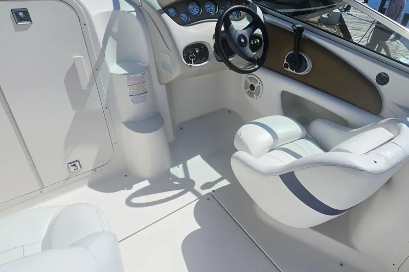 Slide: The Image of Interior of a 2003 Chaparral 215 SS boat, featuring steering wheel and seating. - 13