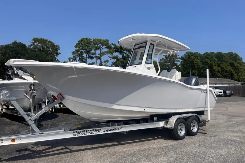 Slide: The Image of 2027 Tidewater 232 LXF boat on trailer, parked outdoors under clear blue sky. - 1