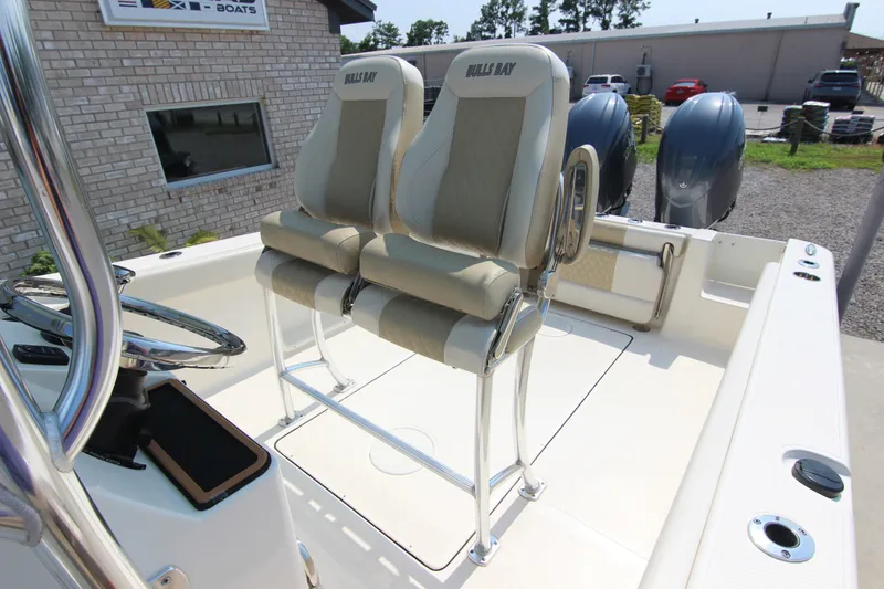 Slide: The Image of 2024 Bulls Bay 255 Center Console boat interior with dual seats and steering wheel. - 19