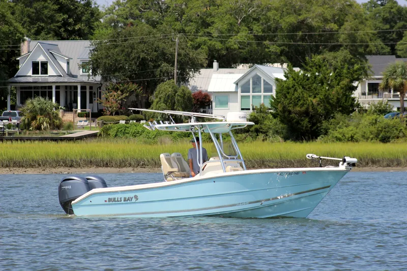 The Image of 2024 Bulls Bay 255 Center Console boat cruising near waterfront homes. - 0