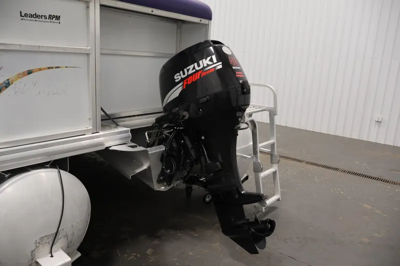 Slide: The Image of 2009 Leisurecraft 22 Cruise with Suzuki outboard motor in a garage setting. - 38