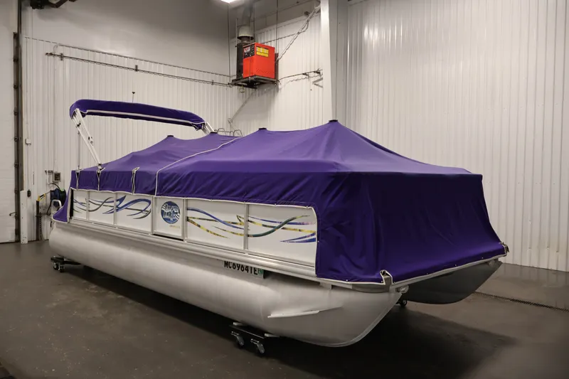 Slide: The Image of 2009 Leisurecraft 22 Cruise pontoon boat with purple cover in indoor storage. - 42