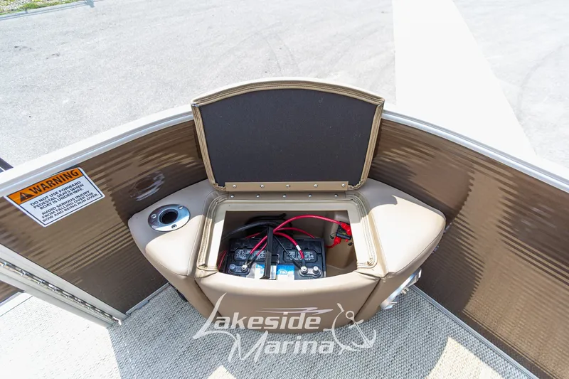 Slide: The Image of 2017 Bennington 22 GFS boat battery compartment with warning label and cup holder. - 18