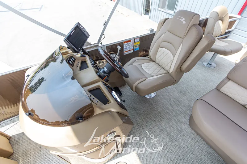 Slide: The Image of 2017 Bennington 22 GFS boat interior with beige seating and modern dashboard. - 24