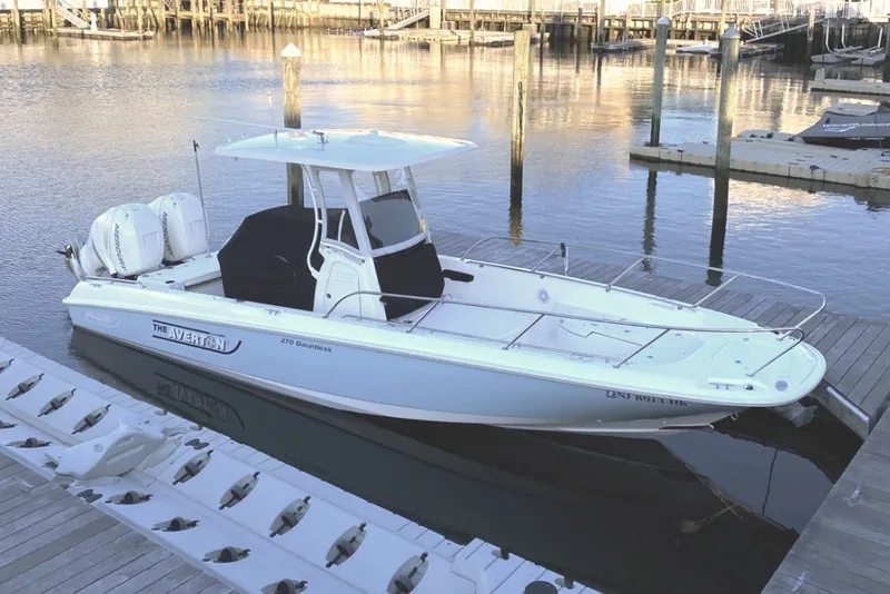The Image of 2015 Boston Whaler 270 Dauntless boat docked in a marina, featuring twin engines. - 0