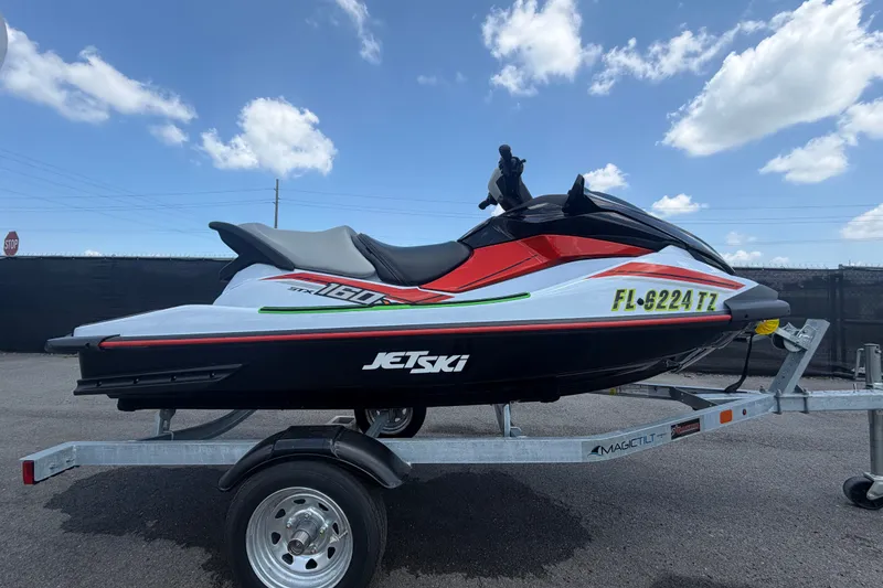 Slide: The Image of 2024 Kawasaki Jetski STX 160X on trailer under blue sky. - 1