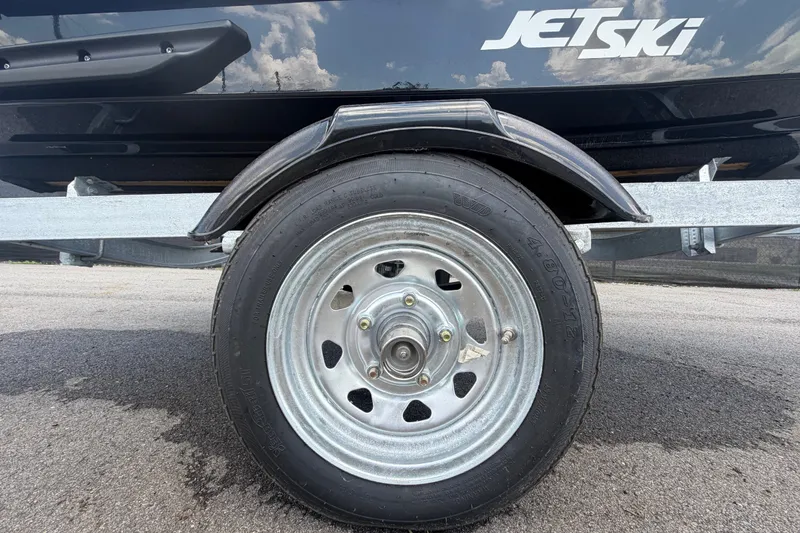 Slide: The Image of Trailer wheel of 2024 Kawasaki Jetski STX 160X on pavement. - 31