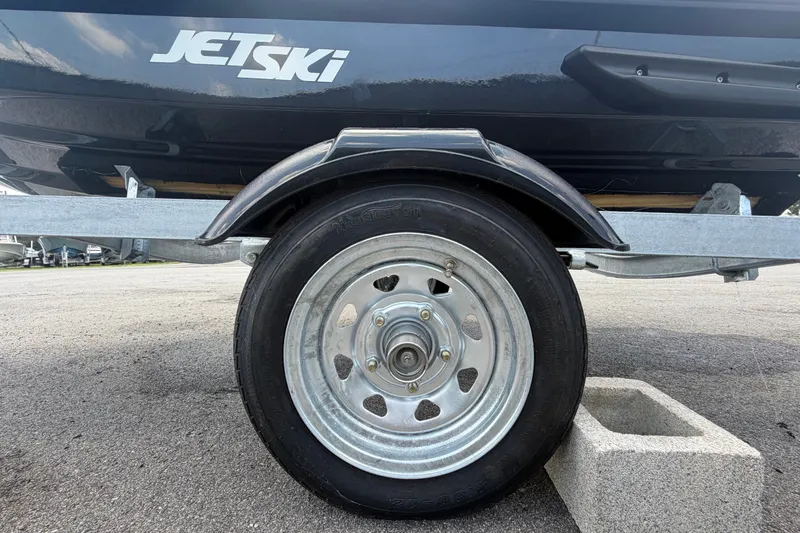 Slide: The Image of Trailer wheel of 2024 Kawasaki Jetski STX 160X on pavement. - 32