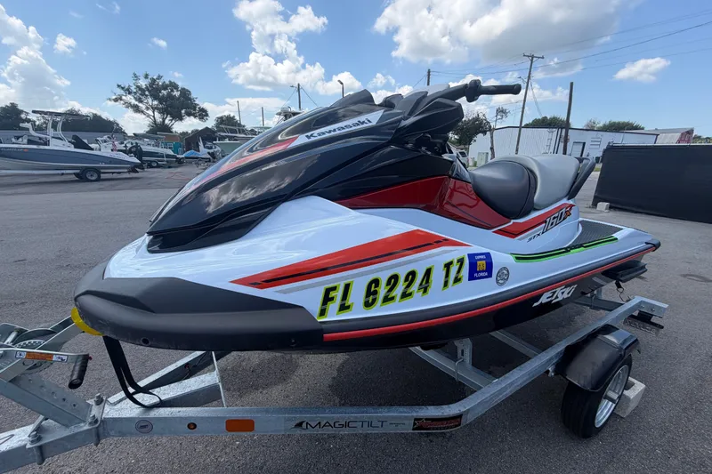 Slide: The Image of 2024 Kawasaki Jetski STX 160X on trailer, parked outdoors under a cloudy sky. - 7