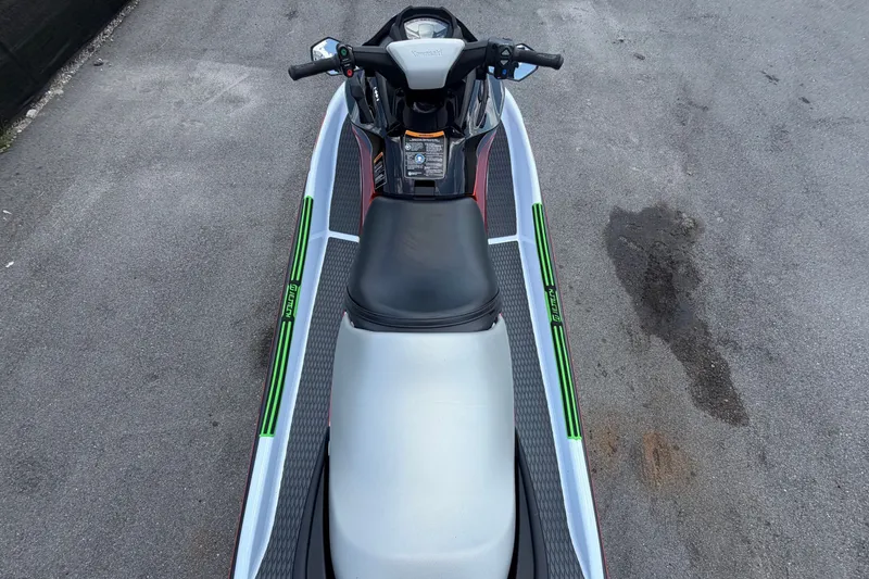 Slide: The Image of A 2024 Kawasaki Jetski STX 160X with a black seat and green accents on a gray surface. - 11