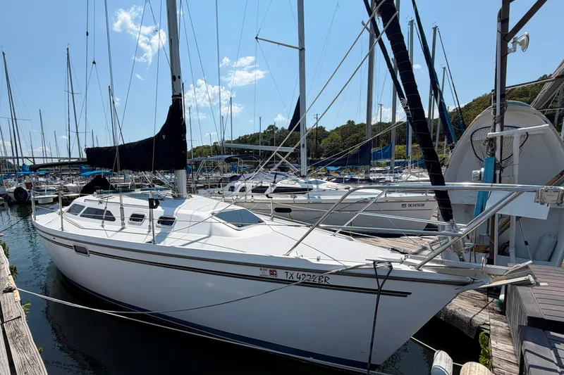 The Image of 1997 Catalina 320 sailboat docked at a marina under a clear blue sky. - 0