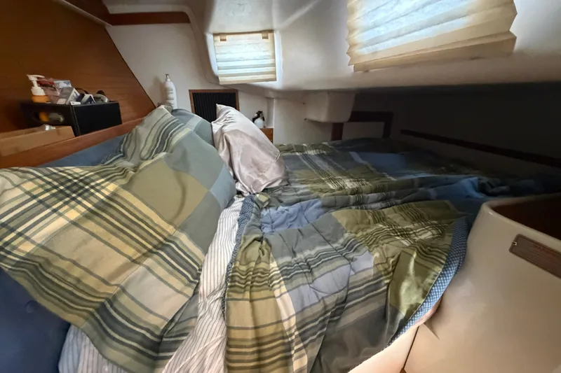 Slide: The Image of Cozy cabin interior of a 1997 Catalina 320 sailboat with plaid bedding. - 20
