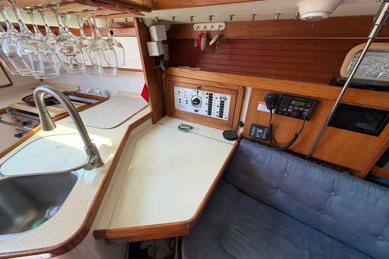 Slide: The Image of Interior of a 1997 Catalina 320 sailboat with kitchen and navigation area. - 16