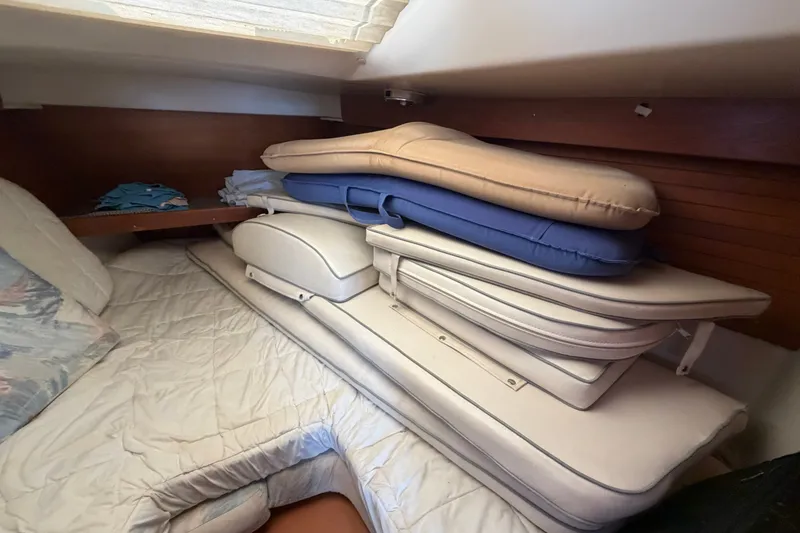 Slide: The Image of Interior cabin of 1997 Catalina 320 sailboat with stacked cushions and bedding. - 27
