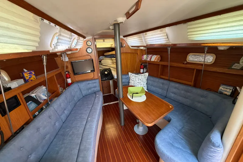 Slide: The Image of Interior of a 1997 Catalina 320 sailboat with cozy seating and wooden accents. - 10