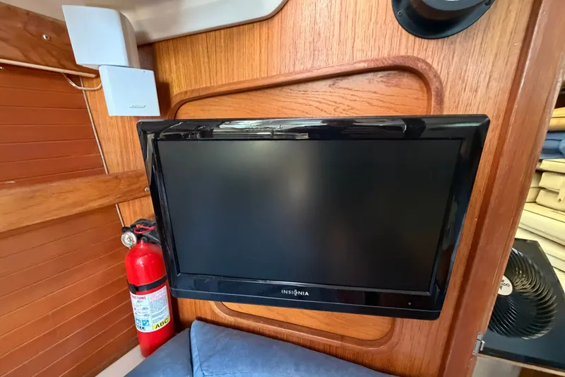 Slide: The Image of Interior of a 1997 Catalina 320 sailboat with TV, fire extinguisher, and speaker. - 14