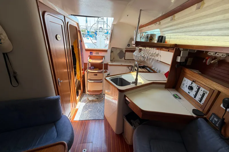 Slide: The Image of Interior of a 1997 Catalina 320 sailboat featuring a compact kitchen and cozy seating area. - 30