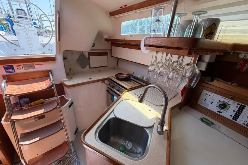 Slide: The Image of Interior of a 1997 Catalina 320 sailboat kitchen with sink, stove, and glass rack. - 31
