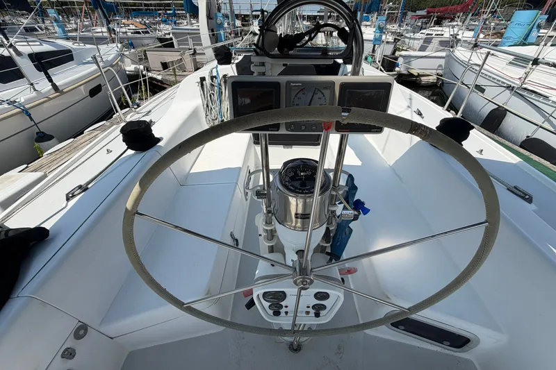 Slide: The Image of Cockpit view of a 1997 Catalina 320 sailboat with steering wheel and navigation instruments. - 7