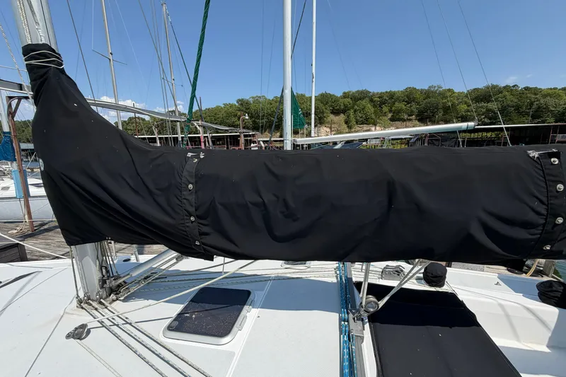 Slide: The Image of 1997 Catalina 320 sailboat with covered boom, docked at marina under clear blue sky. - 33