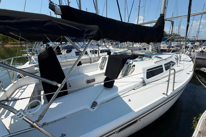 Slide: The Image of 1997 Catalina 320 sailboat docked at marina, featuring sleek design and spacious deck. - 2