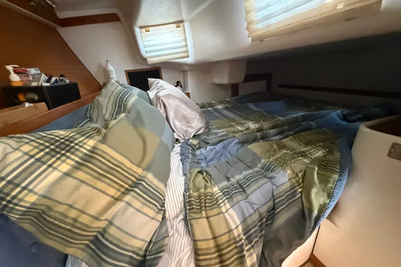 Slide: The Image of Cozy cabin interior of a 1997 Catalina 320 sailboat with plaid bedding. - 21