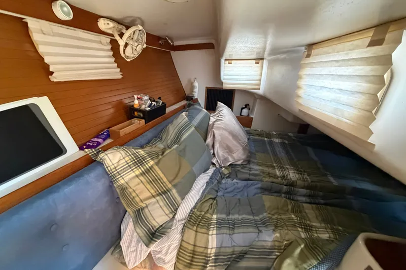 Slide: The Image of Cozy cabin interior of a 1997 Catalina 320 sailboat with plaid bedding and wooden accents. - 22