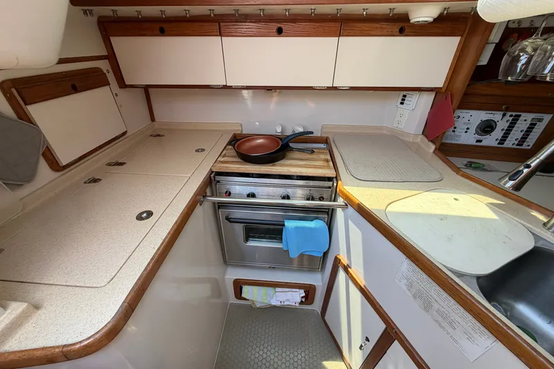 Slide: The Image of Compact kitchen in a 1997 Catalina 320 sailboat with stove, sink, and storage. - 18
