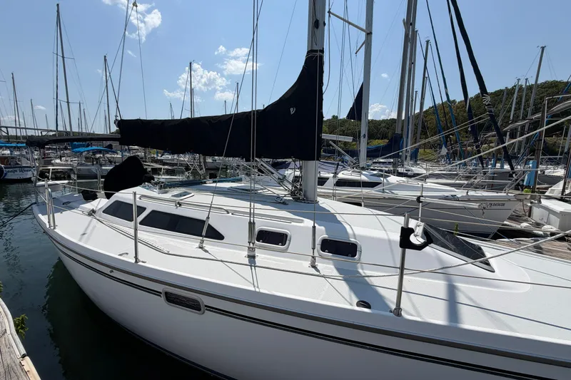 Slide: The Image of 1997 Catalina 320 sailboat docked at marina under clear blue sky. - 1