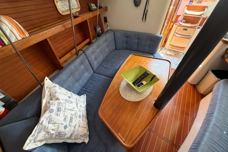 Slide: The Image of Cozy interior of a 1997 Catalina 320 sailboat with blue seating and wooden table. - 28