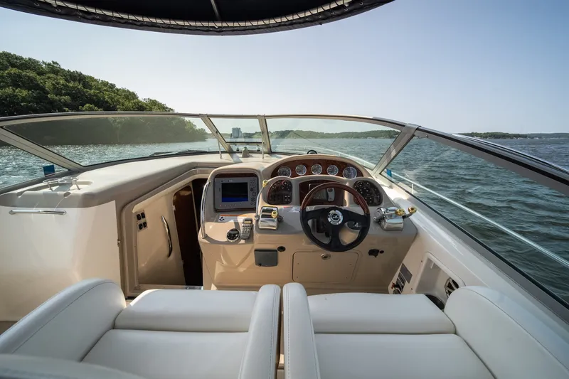 Slide: The Image of 2007 Sea Ray 340 Sundancer cockpit with steering wheel, dashboard, and lake view. - 19