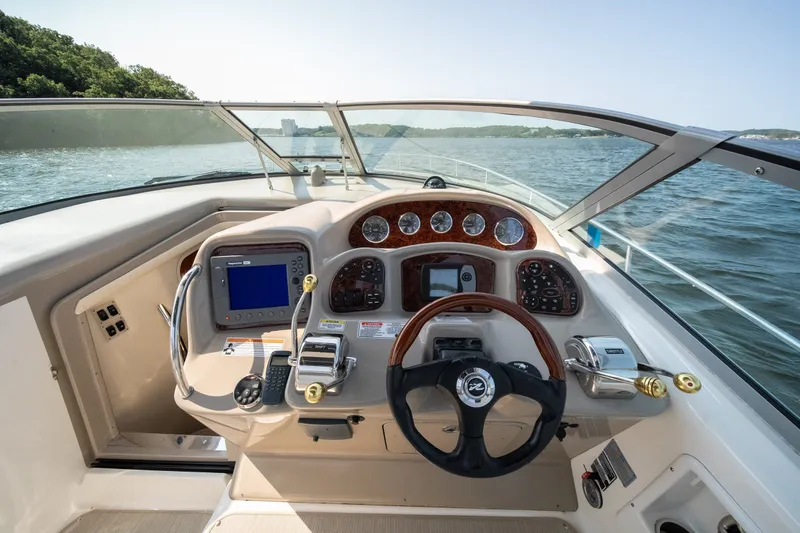 Slide: The Image of 2007 Sea Ray 340 Sundancer helm with navigation controls and steering wheel on open water. - 20