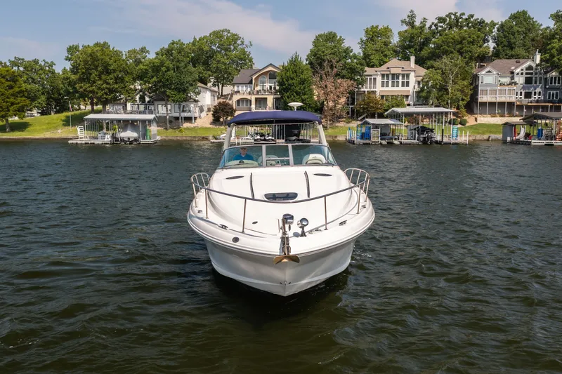 Slide: The Image of 2007 Sea Ray 340 Sundancer yacht on a lake with waterfront homes in the background. - 9