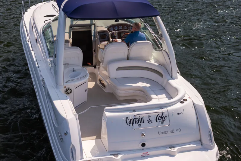 Slide: The Image of 2007 Sea Ray 340 Sundancer boat cruising on water, featuring spacious seating and blue canopy. - 4
