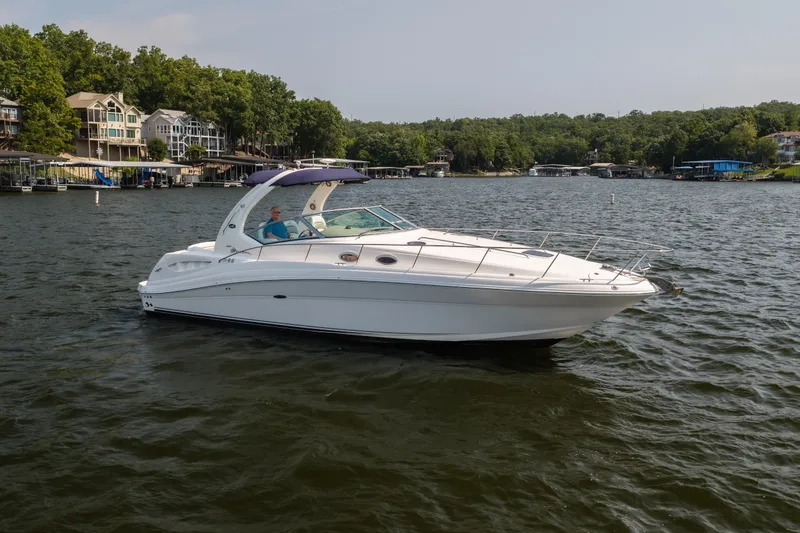 Slide: The Image of 2007 Sea Ray 340 Sundancer yacht cruising on a scenic lake with lush shoreline. - 8