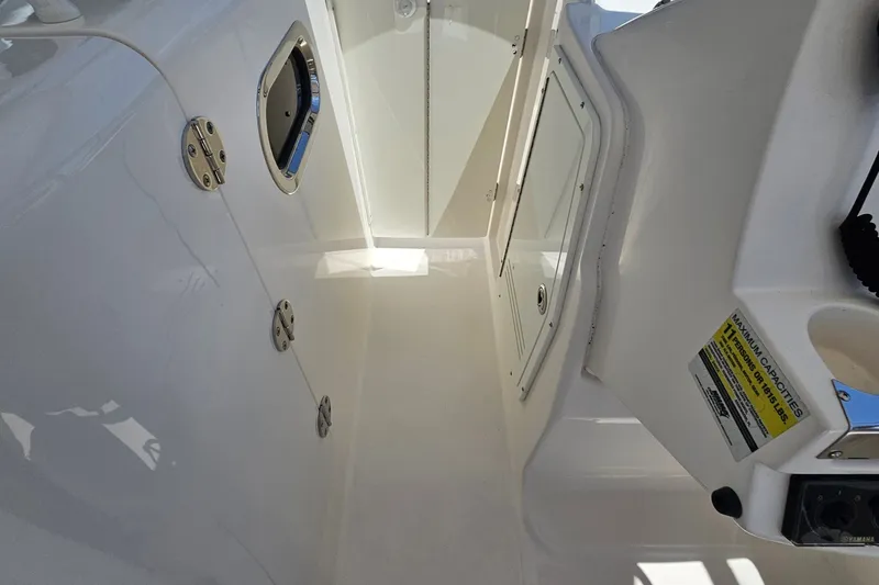 Slide: The Image of Interior view of a 2013 Edgewater 245CX Crossover boat, showcasing storage compartments. - 20