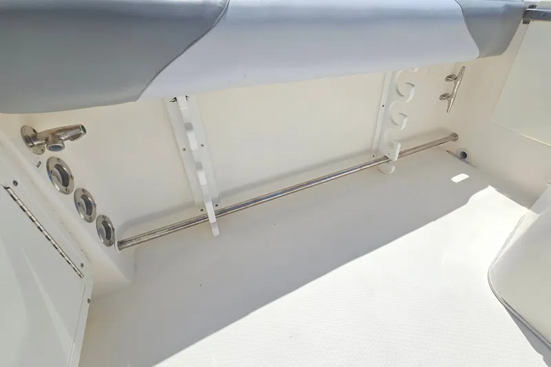 Slide: The Image of Interior view of a 2013 Edgewater 245CX Crossover boat, featuring rod holders and seating. - 13