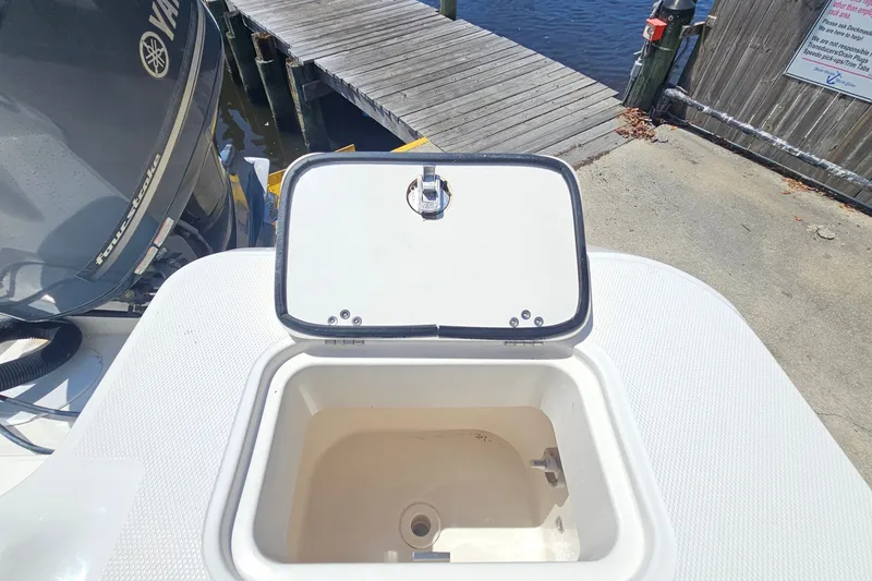 Slide: The Image of Open storage compartment on 2013 Edgewater 245CX Crossover boat near dock. - 10
