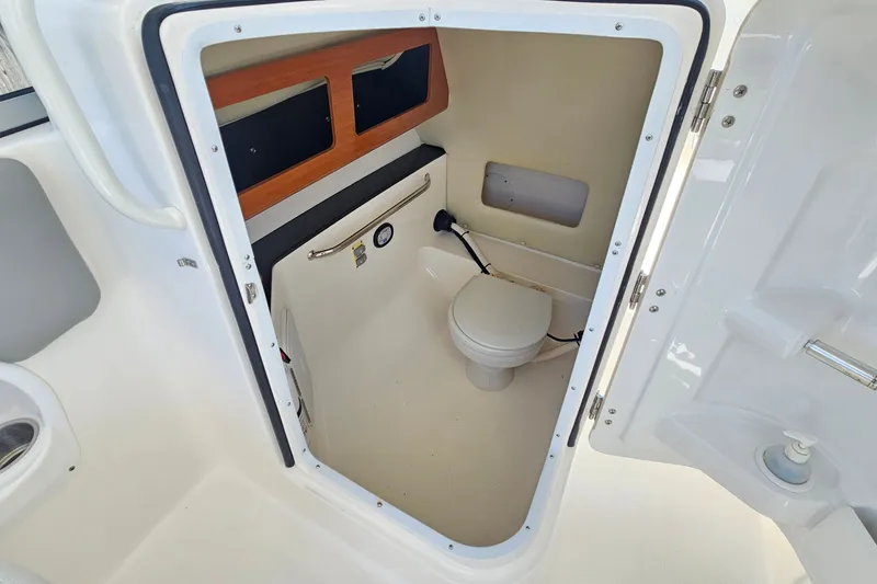 Slide: The Image of 2013 Edgewater 245CX Crossover boat interior with compact marine toilet. - 16