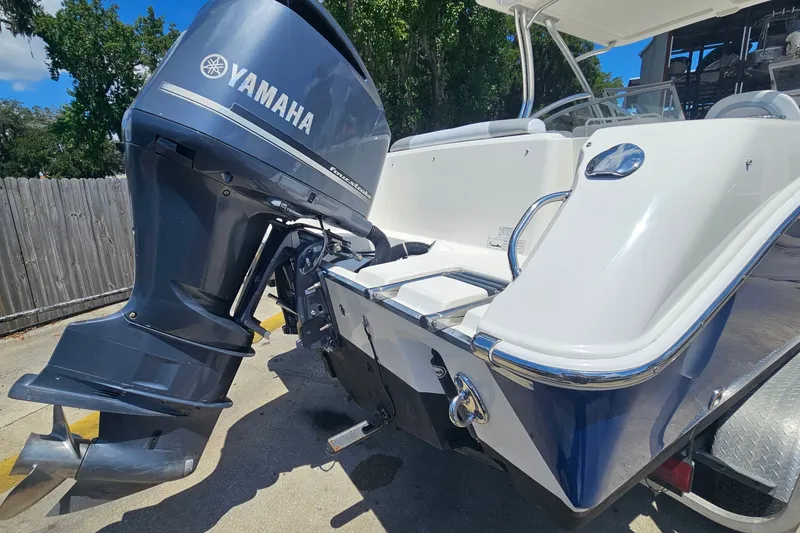 Slide: The Image of 2013 Edgewater 245CX Crossover boat with Yamaha outboard motor, parked outdoors. - 3