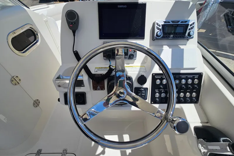Slide: The Image of Steering console of 2013 Edgewater 245CX Crossover boat with controls and navigation equipment. - 19