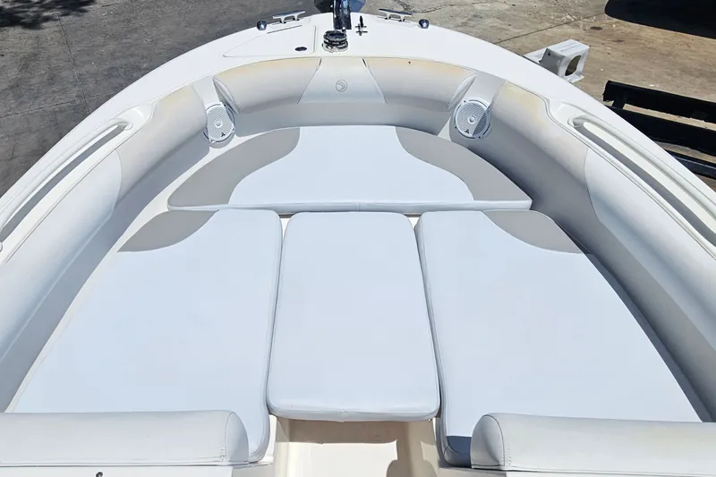Slide: The Image of 2013 Edgewater 245CX Crossover boat interior with cushioned seating and speakers. - 21