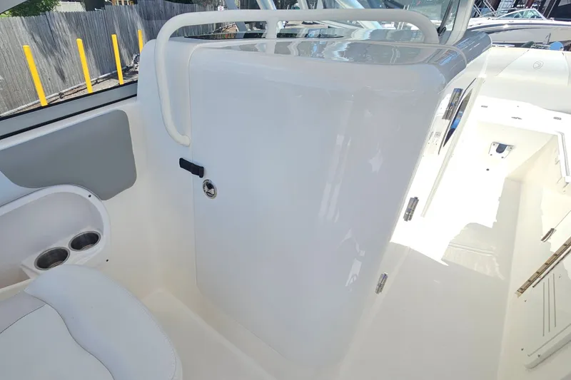 Slide: The Image of Interior view of a 2013 Edgewater 245CX Crossover boat, featuring sleek white surfaces. - 15