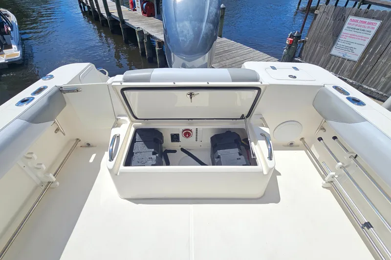 Slide: The Image of 2013 Edgewater 245CX Crossover boat with open storage compartment, docked by the water. - 9