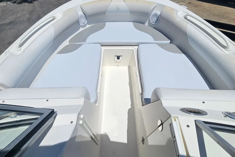 Slide: The Image of 2013 Edgewater 245CX Crossover boat interior with white seating and speakers. - 22