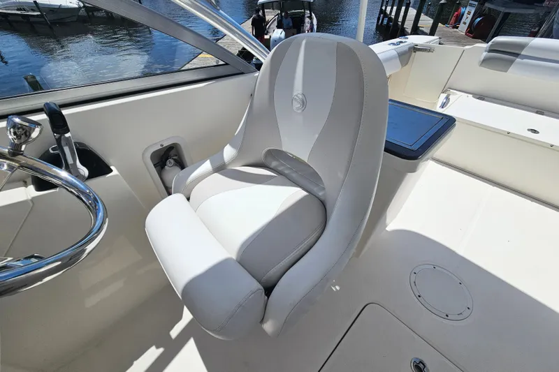 Slide: The Image of Captain's seat on 2013 Edgewater 245CX Crossover boat, featuring sleek design and waterfront view. - 18