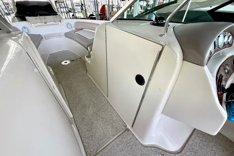 Slide: The Image of 2003 Sea Ray 240 Sundeck interior with seating and dashboard view. - 25