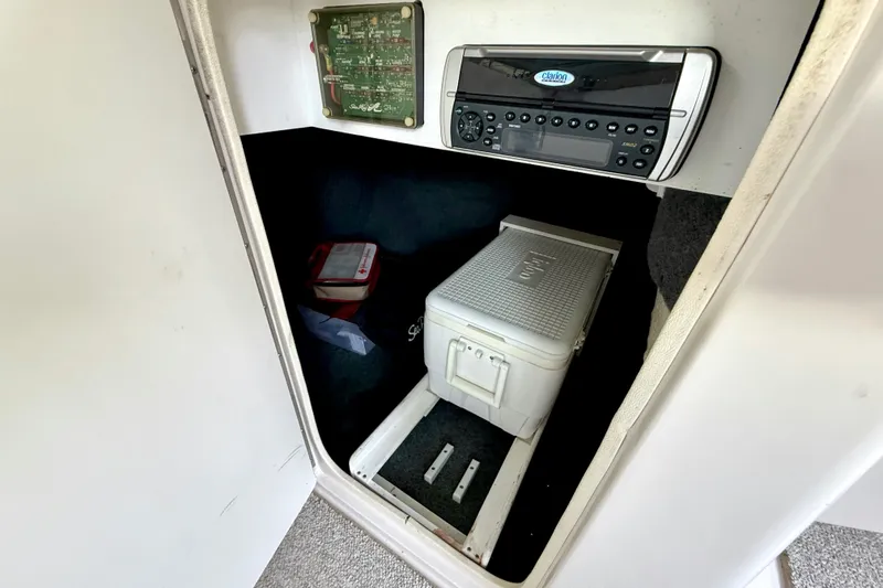 Slide: The Image of 2003 Sea Ray 240 Sundeck interior with stereo system and storage compartment. - 26