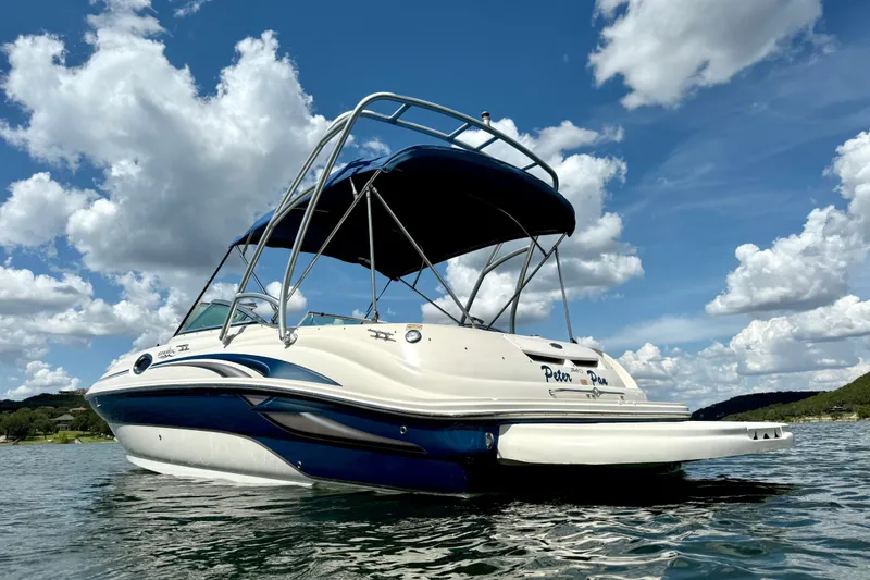Slide: The Image of 2003 Sea Ray 240 Sundeck boat on water under blue sky with clouds. - 5