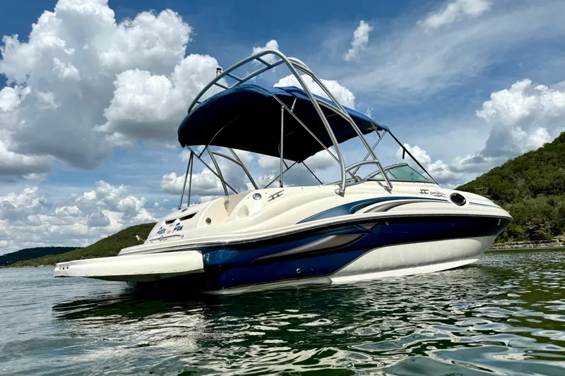 Slide: The Image of 2003 Sea Ray 240 Sundeck boat on water under blue sky with clouds. - 3